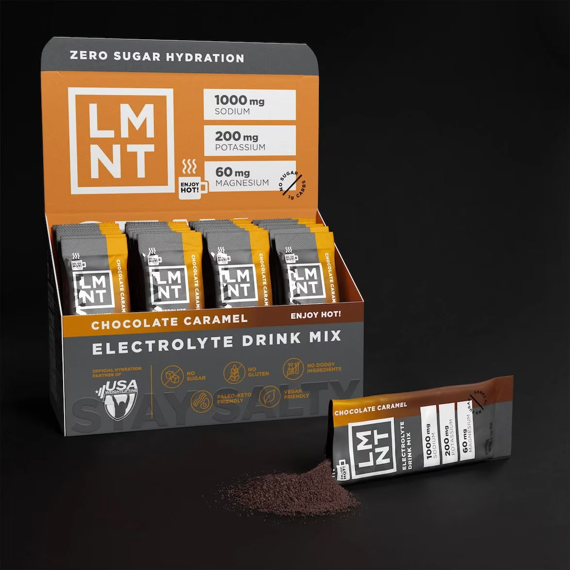 Open box of LMNT Chocolate Caramel stick packs with one sachet beside a small pile of chocolate drink mix powder.
