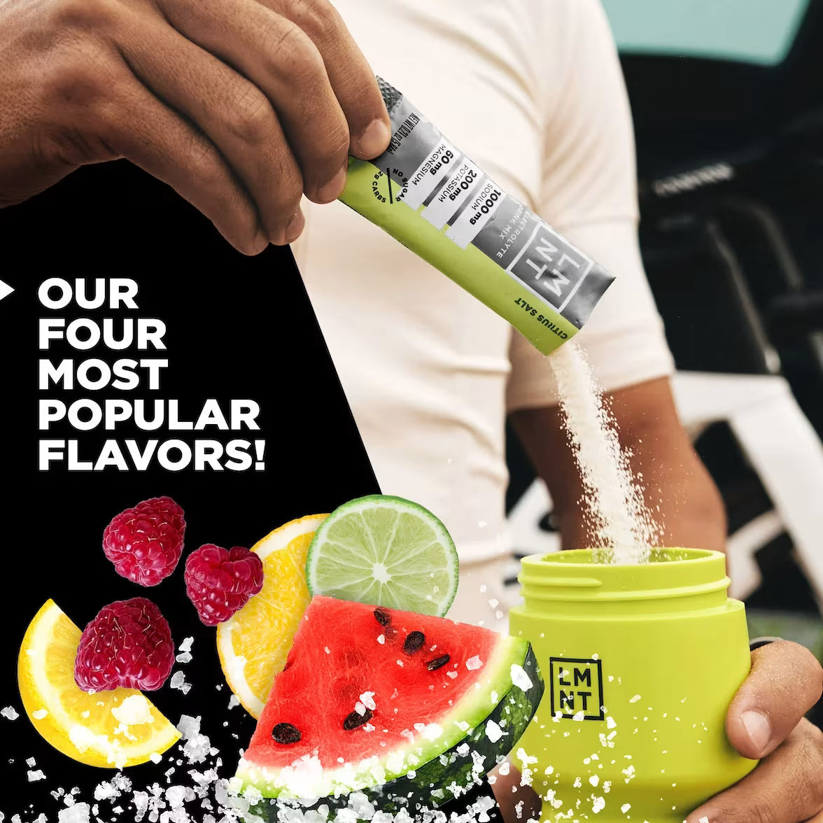 Person pouring LMNT Citrus Salt powder into a green bottle beside lemon, lime, raspberry and watermelon imagery promoting the variety pack’s four flavours.